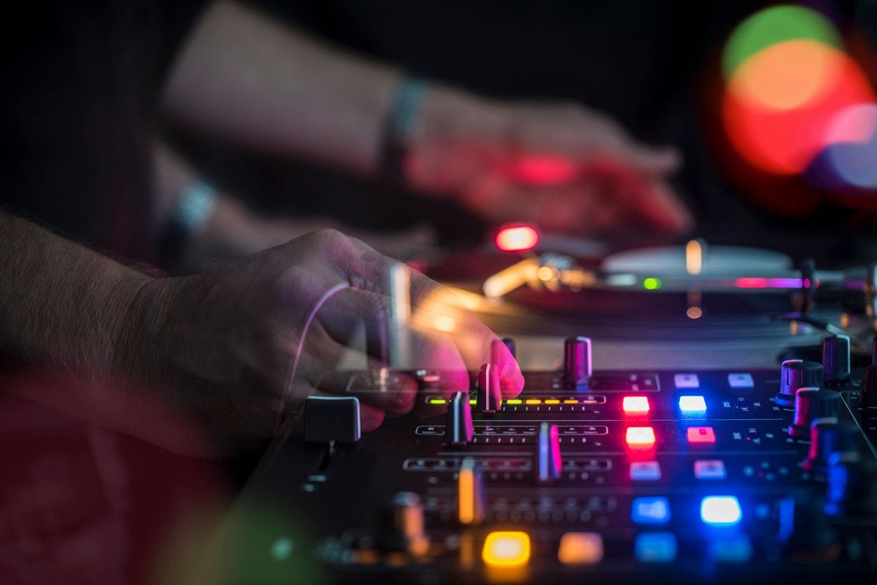 A person adjusting settings on a mixer